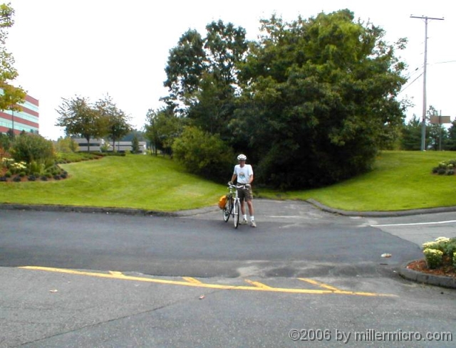 000924CRTatTJX A northbound bicyclist on the CRT, crossing the Speen Street entrance to TJX.
