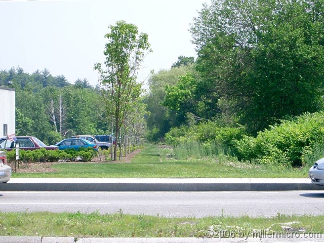 040609NatickMallROW PART 8 - Natick Mall.
In 2006 and 2007, Natick Mall is expanding to become the largest mall in New England. Looking across Speen Street from the new section (the old Wonderbread Plant), we see the old Wonderbread Spur Line heading downhill and east to meet the main CRT at Lake Cochituate.