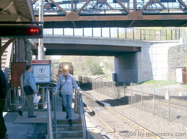 060429NatickStationPlatformAndBottomOfCRT Below the Walnut Street bridge and the Main Street bridge beyond, the start of the Cochituate Rail Trail curves off to the right.