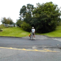000924CRTatTJX A northbound bicyclist on the CRT, crossing the Speen Street entrance to TJX.