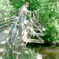 040605JillOnCRTBridge A little east of the CRT and south of Old Connecticut Path, Framingham's Cochituate Brook Reservation includes this lovely bridge at the site of a once-busy mill dam. There's trout in that brook.