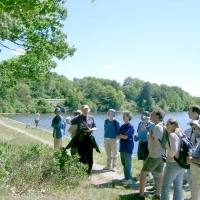 040612JillLeadsNatureWalk Many outdoor events are held every year along or close by the Cochituate Rail Trail. Here, Jill Miller explains natural history on a walk along the granite wall that kept silt out of the adjacent Cochituate Aqueduct Gate House, just north of Route 30 and the Snake Brook Trail.