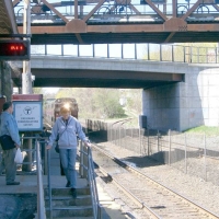 060429NatickStationPlatformAndBottomOfCRT Below the Walnut Street bridge and the Main Street bridge beyond, the start of the Cochituate Rail Trail curves off to the right.