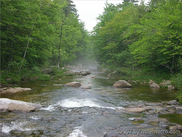 070601ColdRiverCampView2 Misting in the background, it's the Cold River from which this AMC camp takes its name. We're close to camp, just downstream from the local swimming spot and standing on...