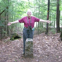 070601ColdRiverCamp_BiStateJill Just beyond the dam, Jill puts one hand in New Hampshire and the other hand in Maine.
