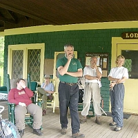 070602ColdRiverCamp_LodgePorch1 Its porch has the usual assortment of rockers and gliders and occupants..