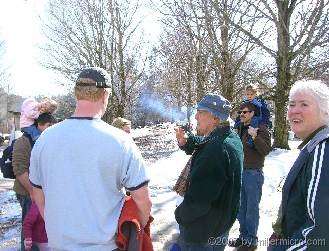 070303DaveDimmick1 Today there are lots of guests, and lots of tours. Dave Dimmick explains how the farmers would line their roads with lanes of maple trees, for easy winter access to the sap buckets.