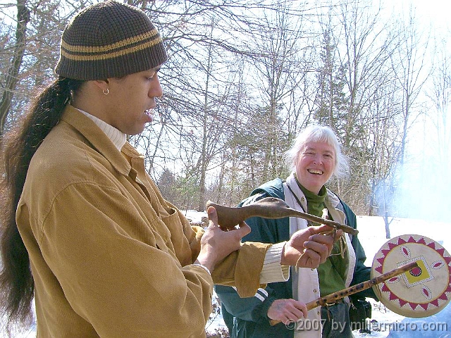 070303WampanoagSpoonEtAl3 The Wampanoag exhibitor, <a href=http://www.mcnaa.org/Speakers/annawon_weeden.html>Annawon Weeden</a>, brought these artifacts from Cape Cod. Here he holds up that duck spoon, as Jill holds a flute and drum. (No, she's not using the flute to beat the drum.)