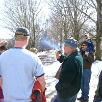 070303DaveDimmick1 Today there are lots of guests, and lots of tours. Dave Dimmick explains how the farmers would line their roads with lanes of maple trees, for easy winter access to the sap buckets.